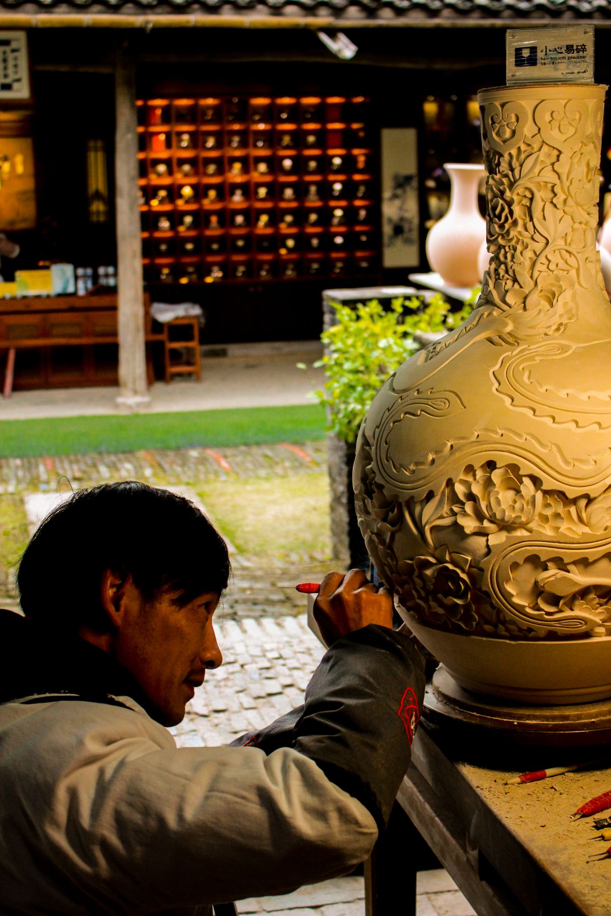 An artisan decorating a vase by hand