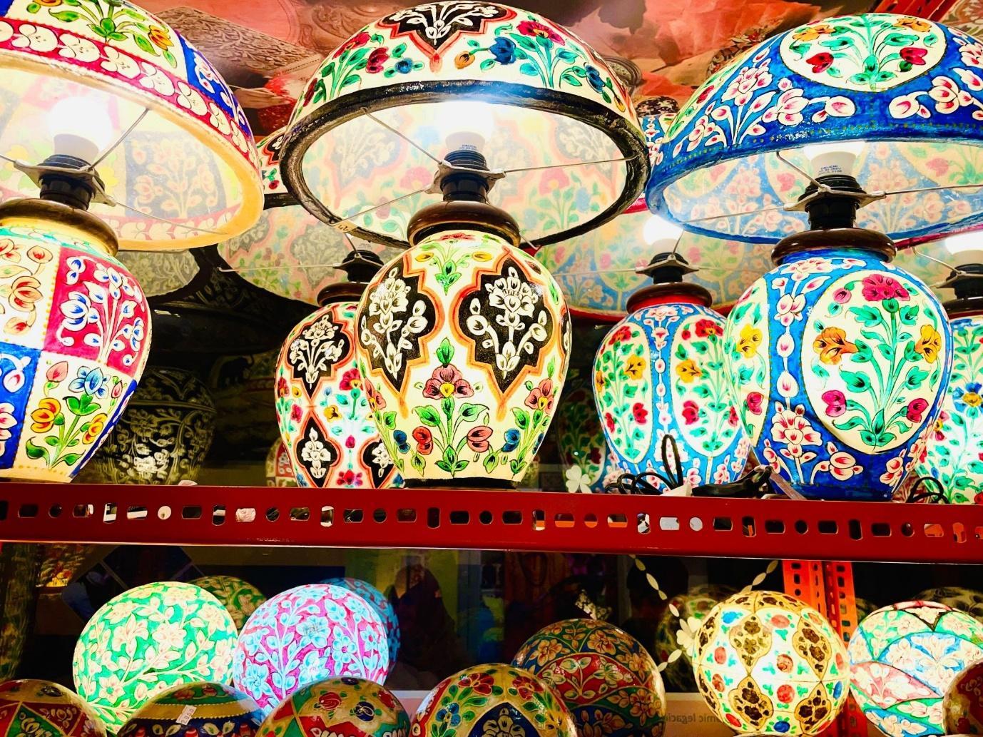 Shelves of hand-painted camel-skin lamps glowing from within