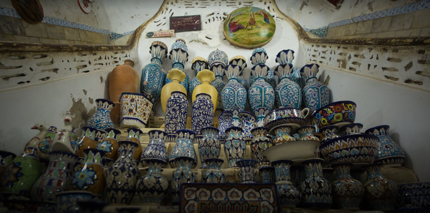 Blue pottery stacked against the old armoury walls