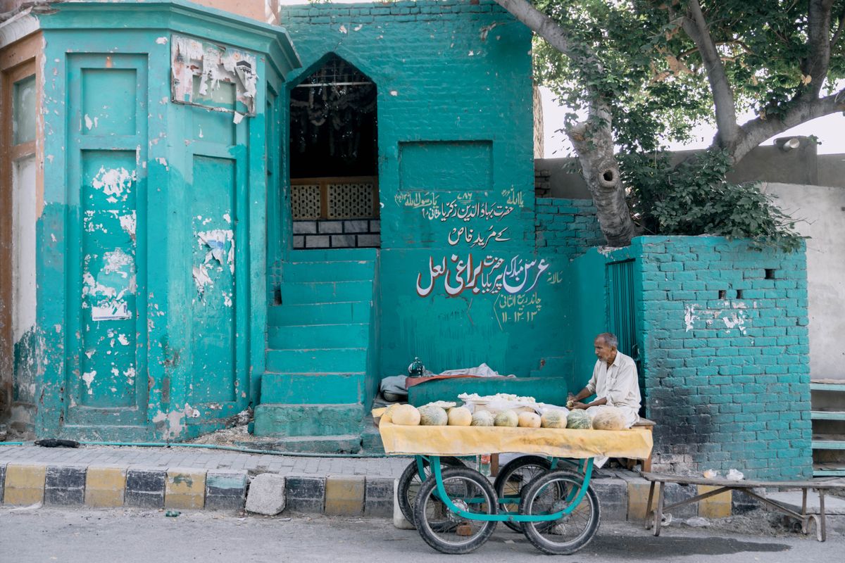 A vendor among teal walls of the old city
